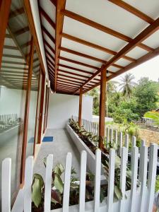 uma cerca branca de estacas num alpendre com plantas em Karyana Apartment em Kuta Lombok