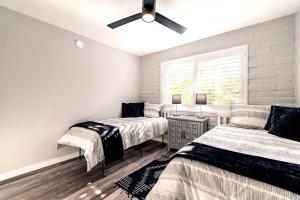 a bedroom with three beds and a ceiling fan at Charming dog-friendly, 2BR-1BA with Pool, Mountain Views - Low Summer Rates! in Tucson