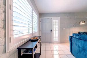 a living room with a blue couch and a window at Charming dog-friendly, 2BR-1BA with Pool, Mountain Views - Low Summer Rates! in Tucson