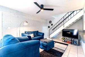 a living room with a blue couch and a ceiling fan at Charming dog-friendly, 2BR-1BA with Pool, Mountain Views - Low Summer Rates! in Tucson +18 photos