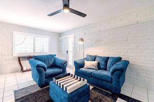 a living room with two blue couches and a ceiling fan at Charming dog-friendly, 2BR-1BA with Pool, Mountain Views - Low Summer Rates! in Tucson