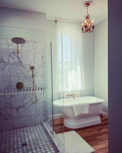 a bathroom with a shower and a tub and a sink at Gallery 904 in Buffalo