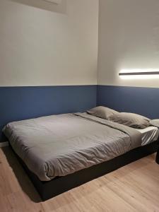 Ce lit se trouve dans un dortoir doté d'un mur bleu. dans l'établissement Number Six Smart Guest House, à Raub
