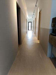 un long couloir avec des murs blancs et un long couloir dans l'établissement Number Six Smart Guest House, à Raub