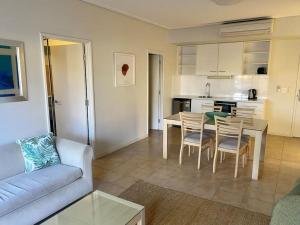 a living room with a couch and a table and chairs at Mariner Resort Comfort - unit 165 in Geraldton