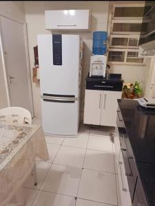 a kitchen with two white refrigerators and a table at Há 1 Quadra da Praia de Icaraí in Niterói