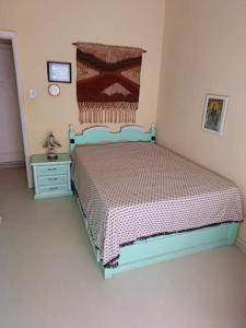 a bedroom with a blue bed and a night stand at Há 1 Quadra da Praia de Icaraí in Niterói