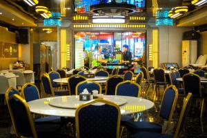 a restaurant with tables and chairs in a room at Home me Hotel in Manila