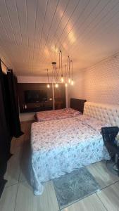 ein Schlafzimmer mit einem großen Bett in einem Zimmer in der Unterkunft Quarto amplo com tv geladeira e fogão in Rio Negro