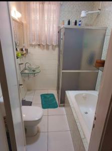 a bathroom with a toilet and a tub and a sink at Há 1 Quadra da Praia de Icaraí in Niterói