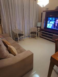 a living room with a couch and a flat screen tv at Há 1 Quadra da Praia de Icaraí in Niterói