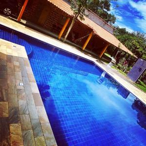- une piscine bleue revêtue de carrelage bleu au sol dans l'établissement Recanto da preguiça, à Igaratá