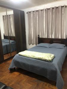 a bedroom with a bed and a large mirror at Tiago Barreto in Poços de Caldas