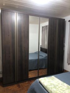 a bedroom with a large wooden cabinet with a mirror at Tiago Barreto in Poços de Caldas