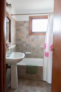 a bathroom with a sink and a bath tub at Bandurrias in Esquel