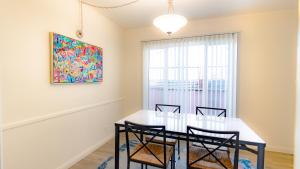 Long Beach Cozy Remodled Home في لونغ بيتش: غرفة طعام مع طاولة وكراسي ولوحة