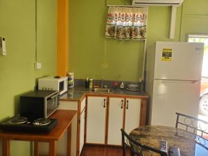 a kitchen with a refrigerator and a table with a microwave at OverNite Comfort in Saint Augustine