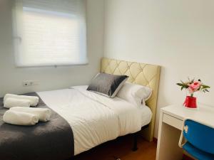 a bedroom with a bed and a vase of flowers at Luxe Forum Beach Terrace in Sant Adria de Besos