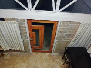 a wooden door in a room with windows at Las escondidas in Pueblo Nuevo