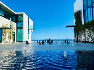 a building with a fountain in front of the ocean at Vidasoul in Boca de la Vinorama