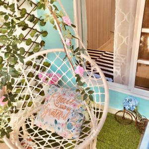 a white wicker chair with a pillow and a plant at Cozzy Flamingo in Concepción de La Vega