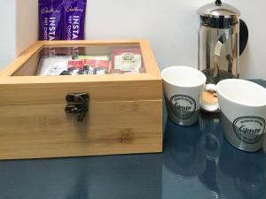 uma caixa de madeira com duas chávenas numa mesa em The Frome Studio em Frome