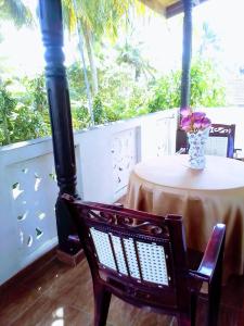 una mesa con un jarrón de flores en un porche en Linu Villa, en Hikkaduwa