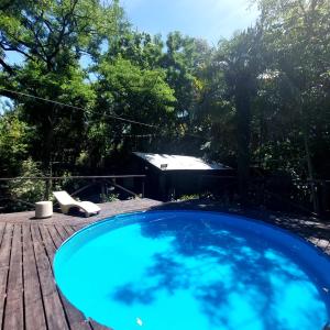 einen großen blauen Pool auf einer Holzterrasse in der Unterkunft Cabaña - El Bamboo Eventos in Arturo SeguÃ­