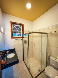 a bathroom with a shower and a sink and a toilet at Pousada do Gentil in Tiradentes