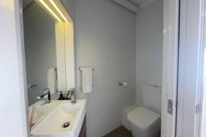 a white bathroom with a sink and a toilet at Lawlers 42 in Mount Hotham