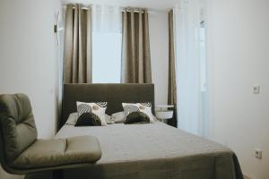 a bedroom with a bed and a chair at Balkon-Apartment in Krefeld: Komfort & Stil nahe Düsseldorf in Krefeld