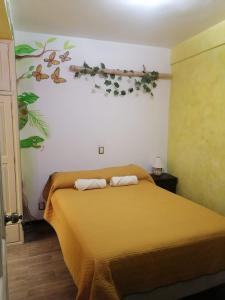 a bedroom with a bed with a orange bedspread at Casa los Arcos Oaxaca in Oaxaca City