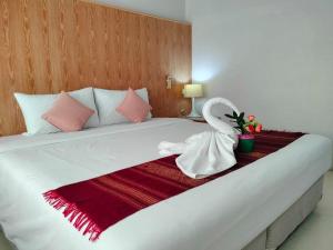 una gran cama blanca con un cisne sentado en ella en S2S Queen Trang Hotel en Trang