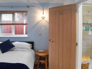 a bedroom with a bed and a wooden door at The Squirrels in Great Malvern
