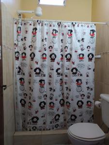 a bathroom with a shower curtain with a santa claus at peixes apart in Puerto Iguazú