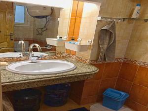 ein Bad mit einem Waschbecken und einem Spiegel in der Unterkunft Men’s Retreat: Cozy Room with Free WiFi & AC in Kairo