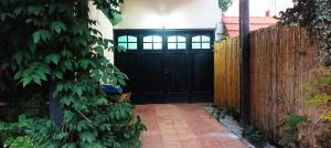a black front door of a house with a fence at Hostal Pino Alto in El Pinar
