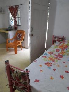 een slaapkamer met een bed, een bureau en een stoel bij CABAÑA MISSRAÍ TROPICAL in Loma del Naranjo