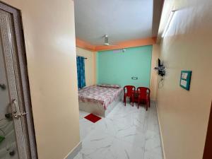 a room with a bed and two red chairs at HOTEL AMARNATH Bakkhali in Bakkhali