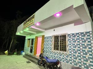 a motorcycle parked in front of a small house at HOTEL AMARNATH Bakkhali in Bakkhali