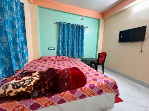 a bedroom with a bed and a tv on a wall at HOTEL AMARNATH Bakkhali in Bakkhali +9 photos