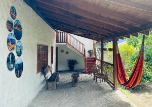 eine Veranda eines Hauses mit einer Hängematte darauf in der Unterkunft Casa Museo - Naturaleza y Tradición in Otavalo