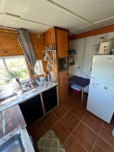 a kitchen with a sink and a refrigerator at Biodiversidad posada familiar in La Pedrera