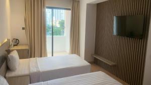 Habitación de hotel con 2 camas y TV de pantalla plana. en Sea Homes en Nha Trang