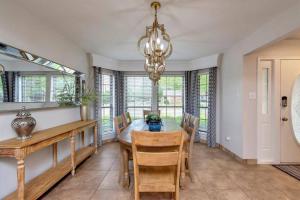 a dining room with a table and chairs and a chandelier at Grapevine Oasis, with Pool in Grapevine