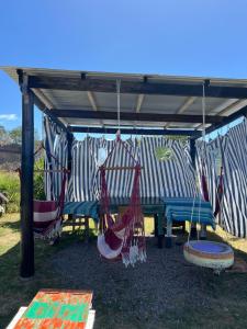a picnic table with hammocks under a gazebo at Biodiversidad posada familiar in La Pedrera