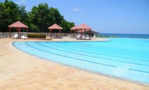 a large swimming pool with tables and gazebos at Ma Douce Guadeloupe in Saint-François +5 photos