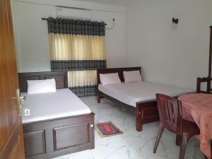Hotel Sanhida Polonnaruwa في بولوناروا: غرفة بسريرين وطاولة وكرسي