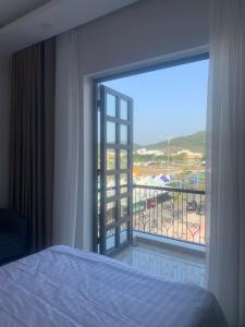 una camera con letto e vista su un balcone di Hà Hùng Panorama Hotel a Hà Tiên