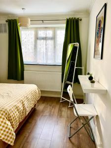 a bedroom with a bed and a desk and a window at Private double room in the center of london in London